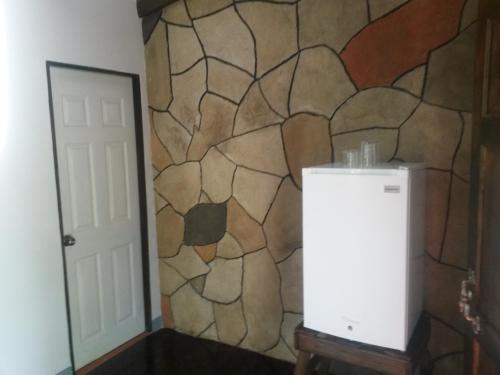 a room with a wall with a stone wall at Nacientes Lodge in Bijagua