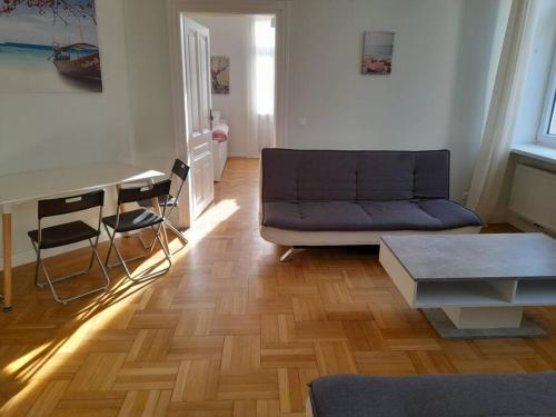 salon z kanapą i stołem w obiekcie Big Family Apartment w Wiedniu