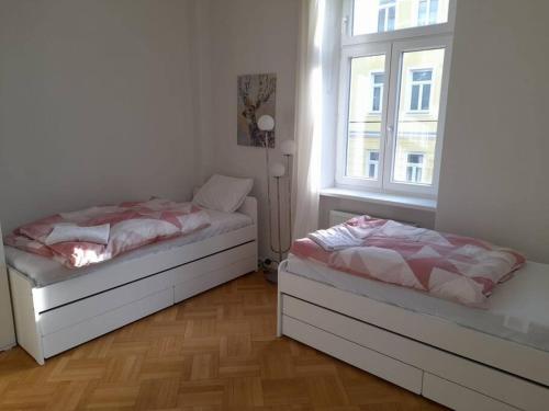 1 dormitorio con 2 camas y ventana en Big Family Apartment en Viena
