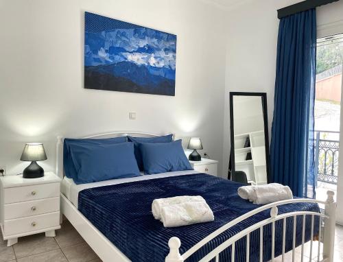 een slaapkamer met een bed met blauwe lakens en een raam bij Villa Serenity Spilia 1st floor in Argostoli