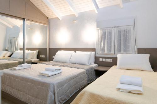 a room with two beds with towels on them at Villa Pearl in Polychrono
