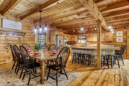 a dining room and kitchen with a table and chairs at Mountain Jewel, Game Room , Fire Pit, Theater Area, WIFI, Pool access!!! in Gatlinburg