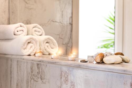 a bathroom counter with towels and candles on it at Villa Pearl in Polykhrono