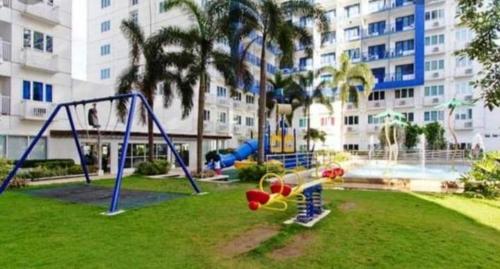 a playground in a park in front of a building at Yhanz Z Sea Residences in Manila