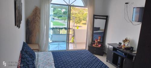 1 dormitorio con cama y vistas a un balcón en Casa Veraneo Flandes con Piscina Privada en Flandes