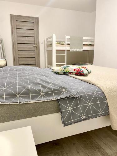 a bedroom with a large bed with a gray comforter at Apartament Słoneczny Ustka in Ustka