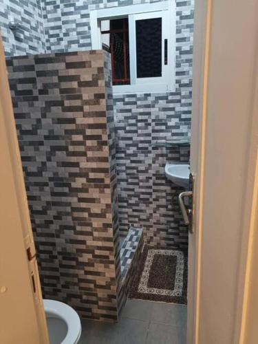 a bathroom with two sinks and a brick wall at Chambre américaine à Angondjé in Libreville