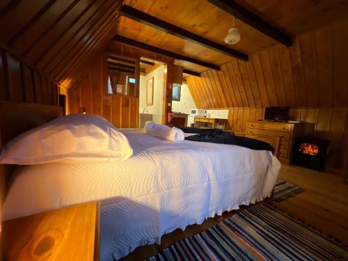 a bedroom with a large bed with white sheets and pillows at Abrigo da Serra- Nature Trails in Santana