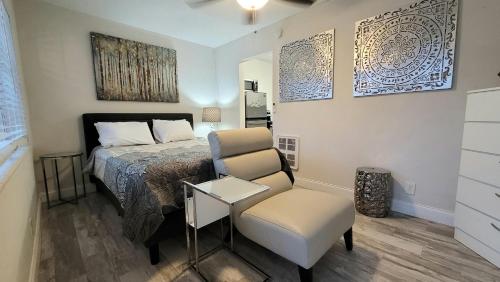 1 dormitorio pequeño con 1 cama y 1 silla en BEACHWAY INN, en Lantana