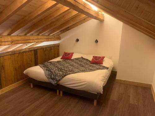 een slaapkamer met een bed met twee rode kussens erop bij Meribel Chalet de Séverine in Les Allues