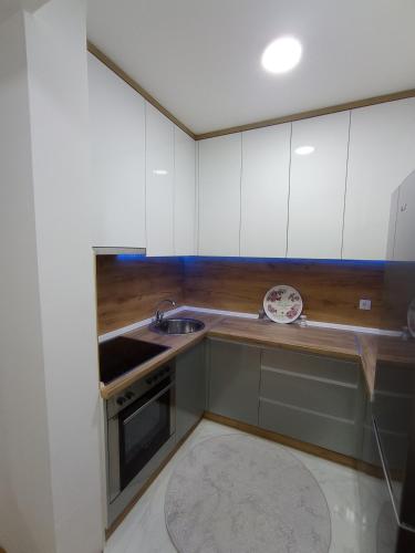 a kitchen with white cabinets and a sink at STAN NA DAN BIJELJINA in Bijeljina