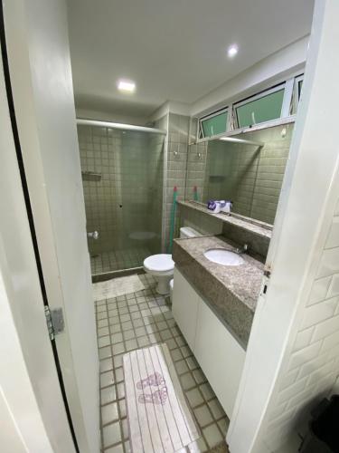 a bathroom with a toilet and a shower and a sink at Ancorar Flat in Porto De Galinhas