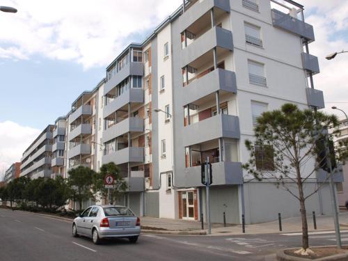 un coche aparcado frente a un edificio alto en 24 D-Habitacion en piso, en San Vicente del Raspeig