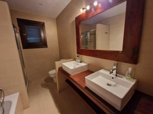 a bathroom with two sinks and a mirror and a toilet at book now spacious 12p villa with communal pool in Las Negras