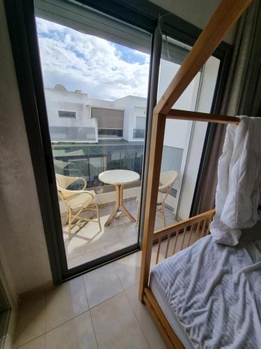 a room with a balcony with a bed and a table at Vill9 in Sidi Rahal