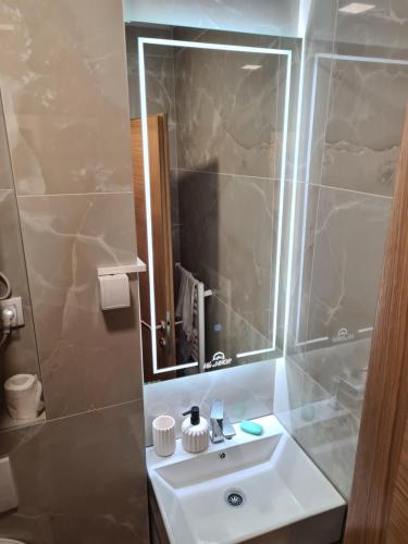 bagno con lavandino bianco e specchio di VilaJahor Natasa A11 a Jahorina