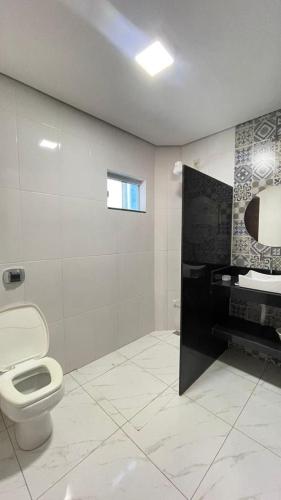 a bathroom with a toilet and a sink at Casa Temporada Aconchego e tranquilidade 3 in Bonito