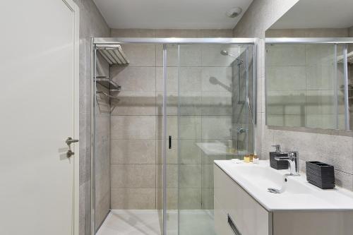 y baño con ducha, lavabo y espejo. en Terraza al Mediterráneo, en Málaga