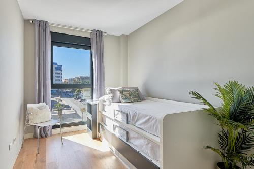 Habitación blanca con cama y ventana en Terraza al Mediterráneo, en Málaga
