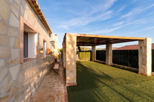 a wooden pergola on the side of a building at Marasolana in Jalón
