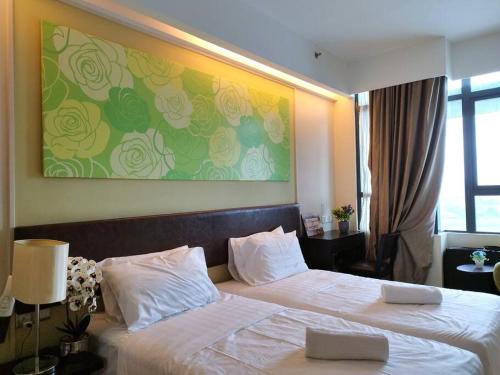 a bedroom with two beds and a painting on the wall at PJ13 1ooMbpsSweetSty3Pax at PJCentrestage in Petaling Jaya