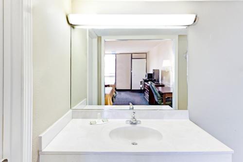 a bathroom with a sink and a mirror at Super 8 Carrollton in Carrollton