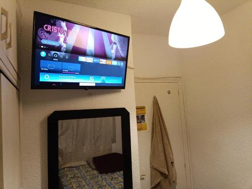 TV de pantalla plana colgada en una pared con espejo en Habitación cama grande doble con smartTV, en Alicante