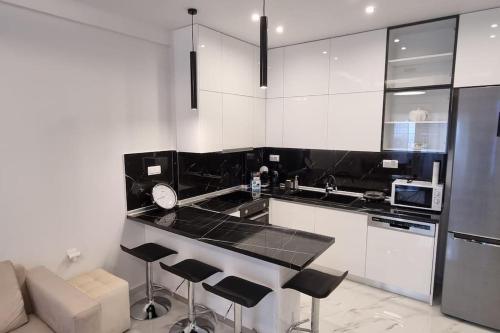 uma cozinha com armários brancos e bancadas pretas em Luxurious Apartment in the Heart of Thessaloniki em Tessalônica