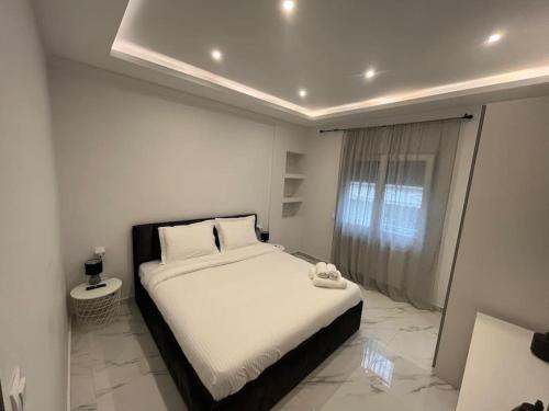 um quarto com uma cama grande num quarto branco em Luxurious Apartment in the Heart of Thessaloniki em Tessalônica