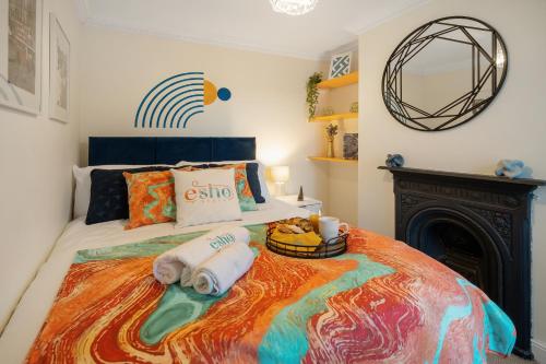 1 dormitorio con 1 cama con toallas y chimenea en Cotswolds - 3 bed house, with Garden, WiFi - Esho Stays, en Cirencester