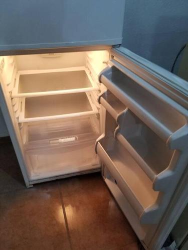 an empty refrigerator with its door open in a kitchen at Departamento 2 camas matrimoniales K, wifi, Aire acondicionado, estacionamiento cruzando calle in Ciudad Valles