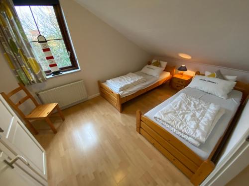 twee bedden in een kleine kamer met een raam bij Lepelaar - Spaanse Galeien 109 in Cadzand