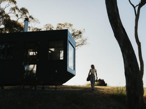 a woman walking in a field next to a house at CABN Clare Valley in Mintaro