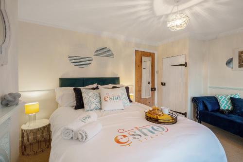 um quarto com uma grande cama branca com toalhas em Spacious home with garden Heart of the town WiFi Smart TV em Cirencester