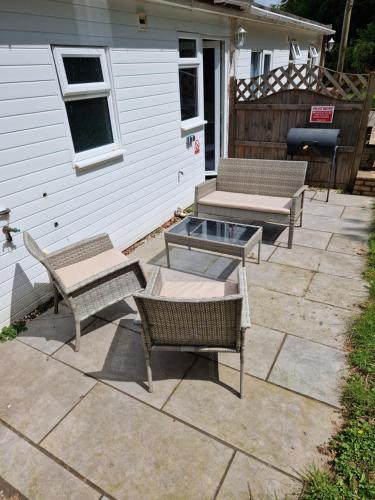 three chairs and a table on a patio at Ranger - Snowdon Cabins holiday let Caernarfon in Caeathro