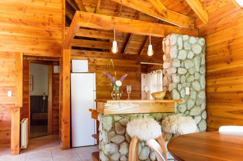 una cocina con mesa y sillas en una cabaña en BOG Jardin de Flores en Villa La Angostura