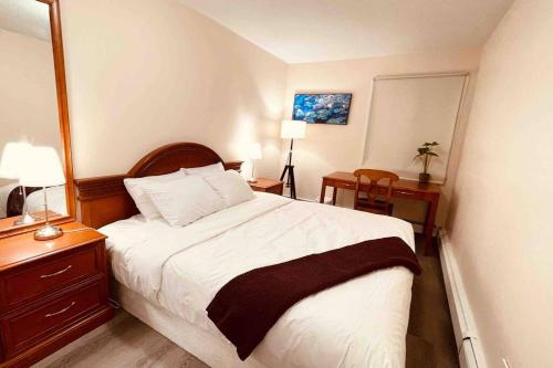 1 dormitorio con 1 cama y escritorio con 2 lámparas en unit #301 Mountain view 1BR in Canmore Down town, en Canmore