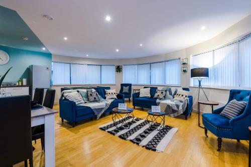 ein Wohnzimmer mit blauen Sofas und blauen Stühlen in der Unterkunft Lovely 2-bed apartment *free parking *pool table in Liverpool
