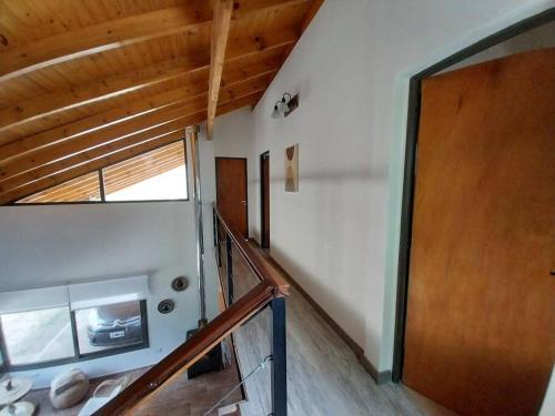 Una escalera en una casa con puerta de madera en Hospedaje ideal a metros del rio en Los Reartes
