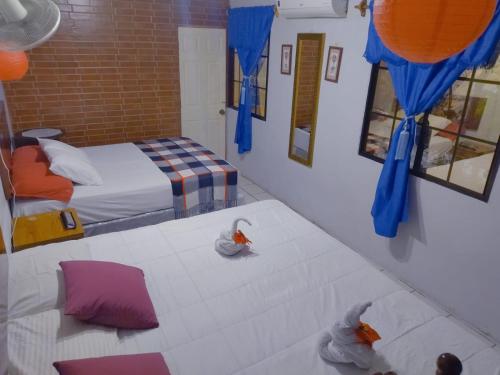 1 dormitorio con 2 camas, cortinas azules y espejos en Hostal Leyendas en León