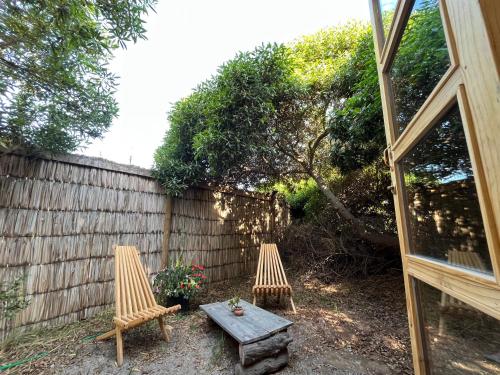 two chairs and a table in front of a fence at El Arbol Eco Lodge in La Serena