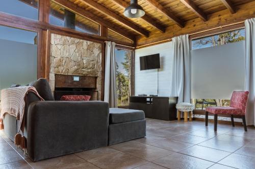 uma sala de estar com um sofá e uma televisão em BOG Dolce Far Niente em Villa La Angostura
