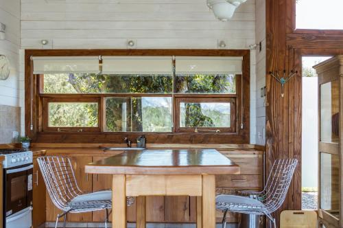 a kitchen with a wooden table and two chairs at BOG Dolce Far Niente in Villa La Angostura