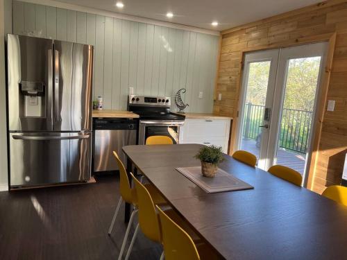 una cucina con tavolo e frigorifero in acciaio inox di Family friendly cottage ☆walking distance to beach a Lion's Head