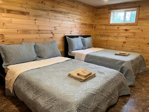 due letti in una stanza con pareti in legno di Family friendly cottage ☆walking distance to beach a Lion's Head