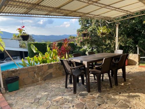 a wooden table and chairs under a pergola at Quinta Baroe in Guaduas