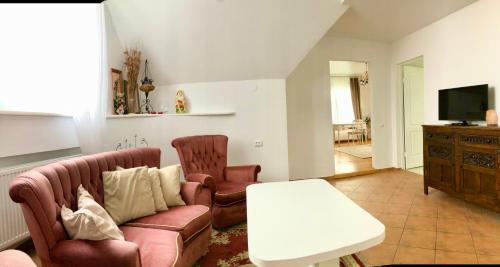 un soggiorno con divano e 2 sedie di Cozy house with spacious backyard a Akademija