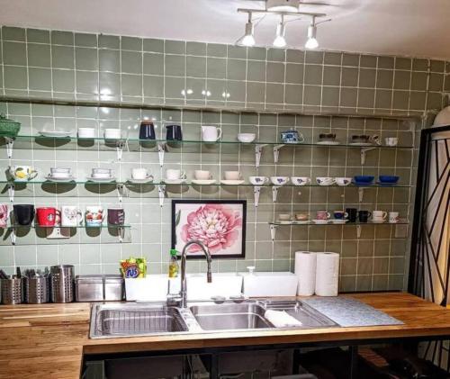 a kitchen with a sink and a green tiled wall at Big Groups Heaven in Central Location in Bangkok