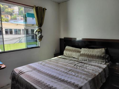 1 dormitorio con 1 cama grande y ventana en Fror de Marina, en Arraial do Cabo