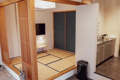 - une cuisine avec une porte coulissante dans une chambre dans l'établissement Spacious One Room Apartment for up to 5ppl w Kitchenette, à Kumamoto